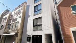 A multi-story building with a modern facade, featuring a mix of balconies and windows. - Nestay apartment Tokyo Ginza (Tokyo)