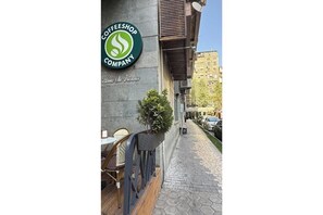 A coffee shop with a sign reading "Coffee Shop Company" and a small outdoor seating area with chairs and a table. - Sweet Home 2-bedroom apartment on Northern ave (Yerevan)