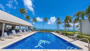 Une piscine avec des chaises longues et vue sur l’océan.