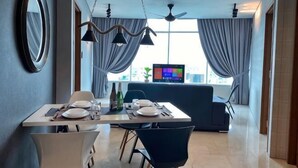 Ett modernt hotellrum med en matplats, en TV och utsikt över staden.