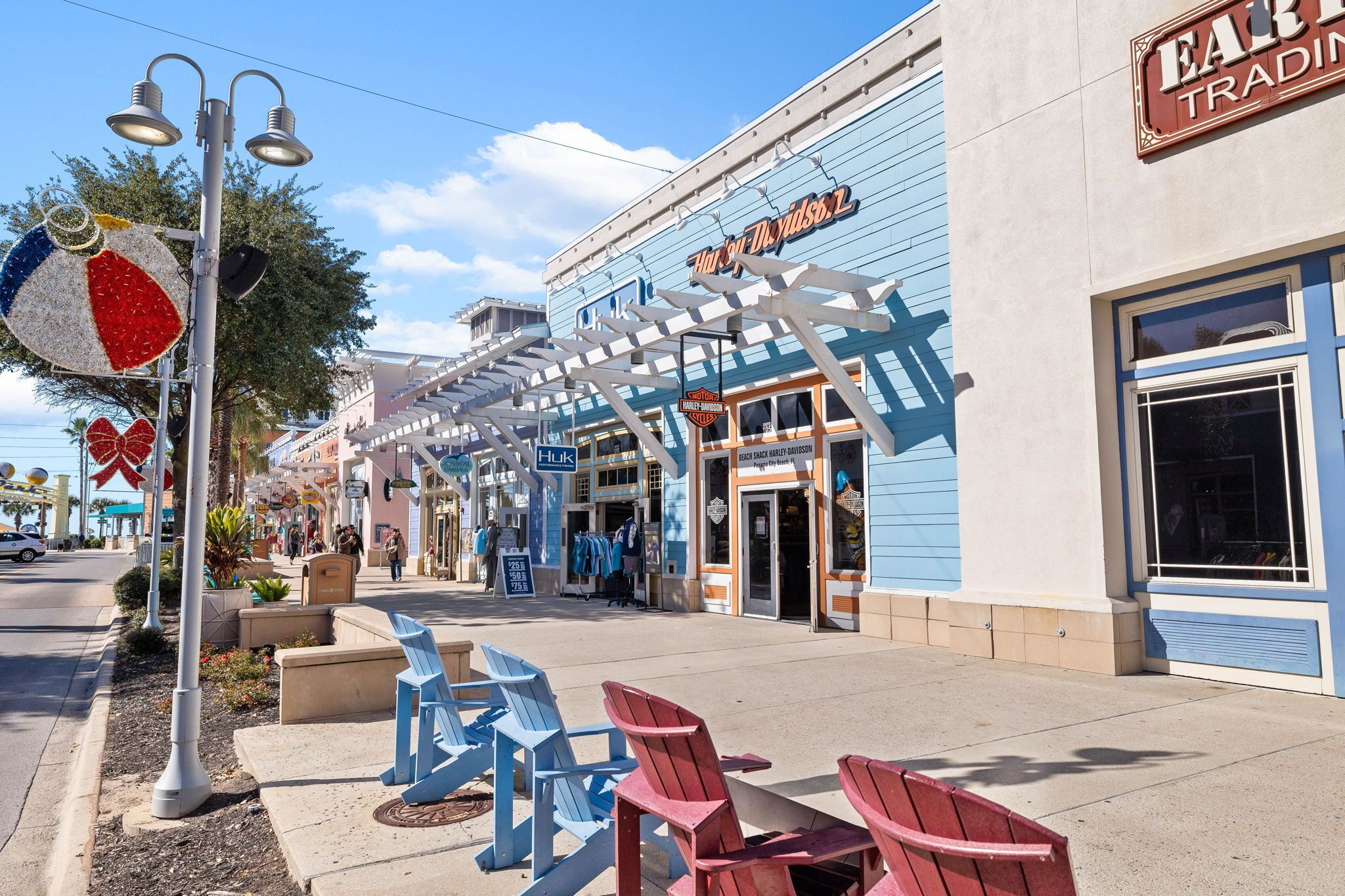 A storefront with a blue awning and a sign that reads "Harley-Davidson Trading Co."