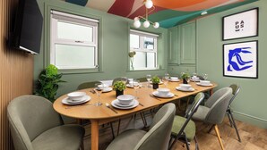 A dining room with a long table set for six, green walls, and a colorful ceiling. - 6 Bedroom Victorian Terrace, 3.5 baths (Hensingham)