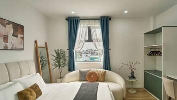 Un dormitorio moderno con cama, mesita de noche, silla, armario y ventana con cortinas.