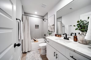 Une salle de bain moderne avec une baignoire, des toilettes et un lavabo.