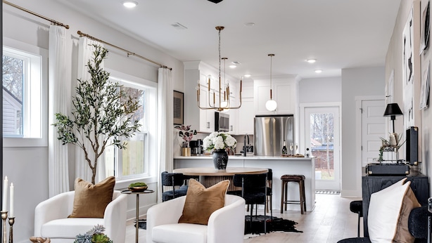 A modern living room with white sofas, a coffee table, and a dining area with a chandelier. - The Boro Suite I 3BR Near Downtown & MTSU w/ Ping Pong (Murfreesboro)