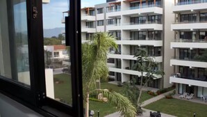 A modern apartment building with multiple balconies, a swimming pool, and outdoor seating. - Cozy Family Condo - Pool & terrace - 10 minute to the beach - Nuevo Vallarta (Nuevo Vallarta)