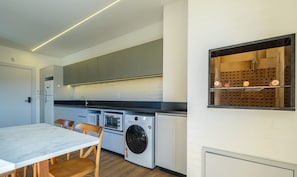 Una cocina moderna con armarios grises, horno integrado y lavadora.