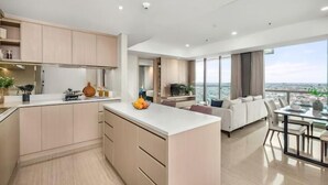 A modern apartment with a kitchen, dining area, and living room, featuring a large window with a city view. - Fairview House - Luxstay near Airport (Kelapa Dua)
