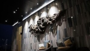 A modern interior with a textured wall, a sofa, and a chair. - Fairview House - Luxstay near Airport (Kelapa Dua)