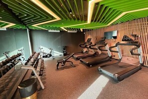 Ein Fitnessstudio mit Laufbändern, Kurzhanteln und Trainingsgeräten.