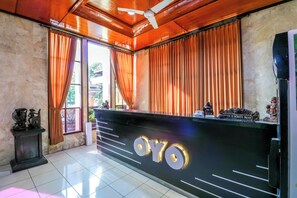 A reception area with a black counter displaying the name "OYO". - Super OYO 1952 Hotel Dewata Indah (Denpasar)