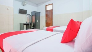 Ein Hotelzimmer mit zwei Betten, einem Fernseher, einem Schrank und einer Tür.