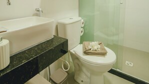 A modern bathroom with a sink, toilet, and glass-enclosed shower. - Beach apartment on the Brazilian northeast coast - Maracaípe. (Ipojuca)