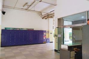 A hallway with a blue storage unit, a glass door entrance, and a visible kitchen area.