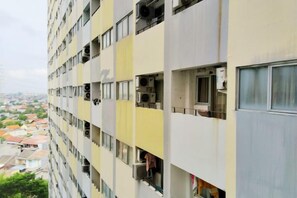 A multi-story building with balconies, air conditioning units, and a view of the surrounding neighborhood. - The Royale Sentra Tower Kuning Powered by Cocotel (East Jakarta)