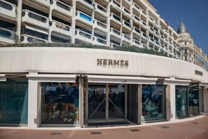 Ein Geschäft von Hermès mit einer modernen Fassade, großen Glasfenstern und freiem Blick ins Innere.