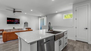 A modern kitchen with a central island, stainless steel appliances, and a built-in dishwasher. - Stylish Retreat - Close to Downtown - Open Layout (Austin)