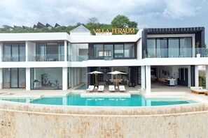 Eine moderne Villa mit Pool, zwei Etagen und einem Namensschild 'Villa Teraum'.
