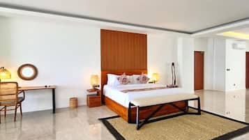 A modern hotel room with a large bed, bedside lamps, a desk, and a chair.
