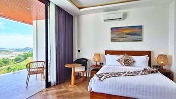 Habitación de hotel con una cama grande, dos mesitas de noche con lámparas, una silla y vistas al exterior.
