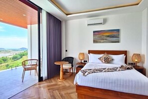 A hotel room with a large bed, two bedside tables with lamps, a chair, and a view of the outdoors. - Villa Teraum (Pujut)