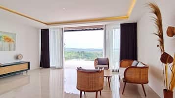 A spacious living room with a large window, a dining area, and a view of the outdoors.