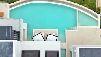 A pool with a curved edge and a white and black framed window.