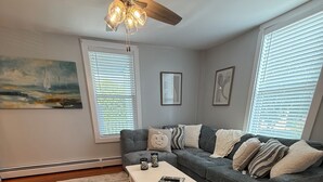 A living room with a gray sofa, a white coffee table, and a patterned rug.