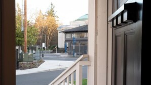 A view from a window overlooking a street with a building in the background.