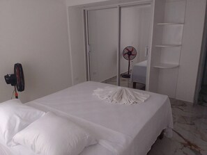 A bedroom with a bed, a fan, a wardrobe, and a chair. - The Perfect Place in Samana (Samaná)