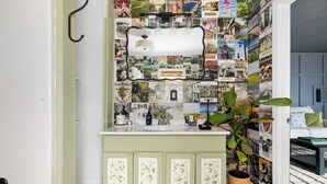 Une salle de bain avec un lavabo, un meuble et un mur recouvert de découpages de magazines.