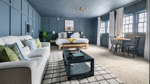 Une pièce comprenant un lit, un canapé, une table basse et un coin repas avec des chaises.