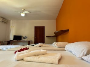 A hotel room with two beds, a television, a ceiling fan, and a door. - Pousada Sunset (Itacaré)