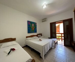 Habitación de hotel con dos camas, un cuadro en la pared y una puerta que da a un balcón.