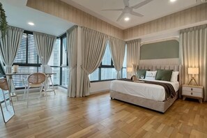 Ein Hotelzimmer mit Bett, Nachttisch, Lampe und Blick auf die Stadt.