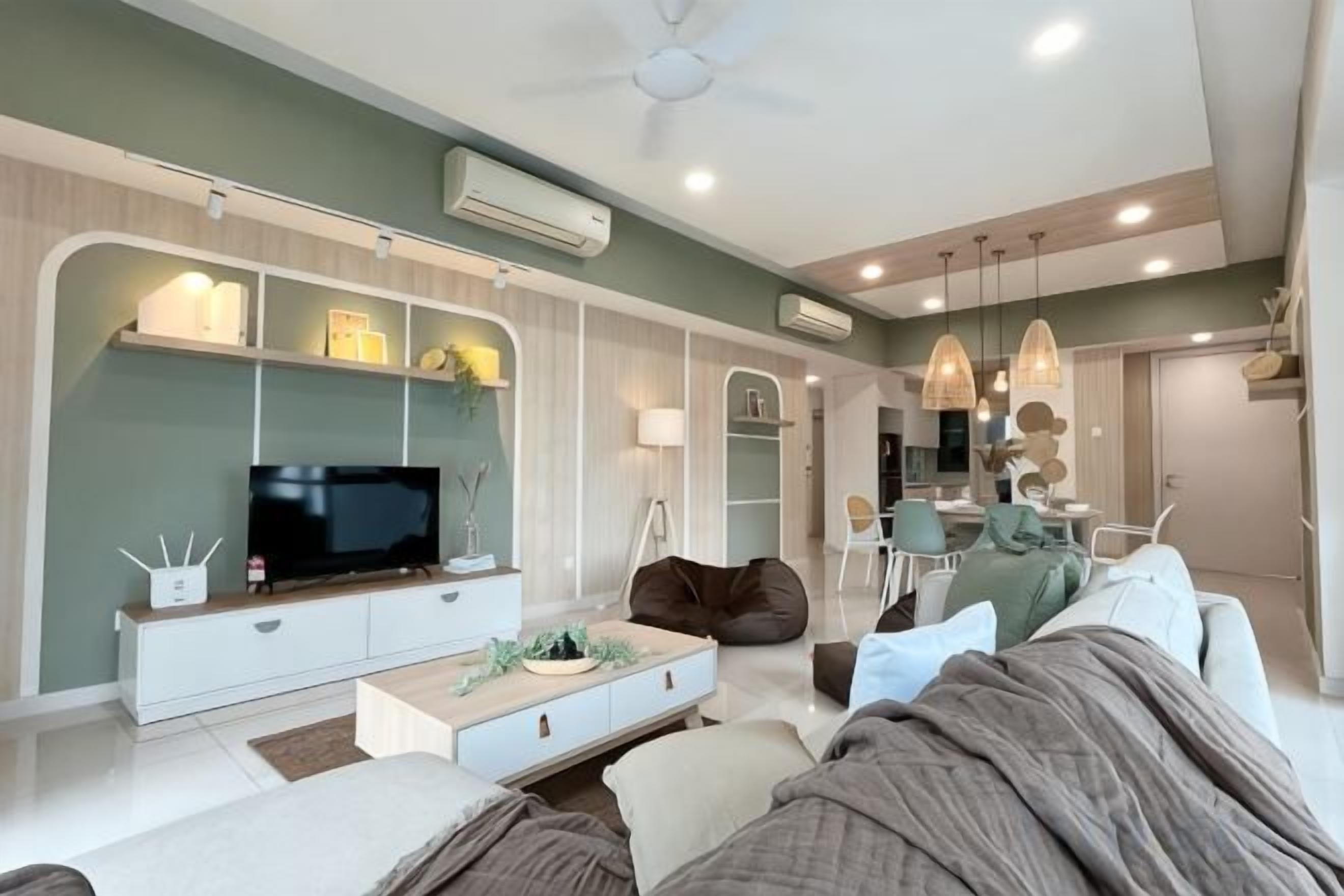 A modern living room with a flat-screen TV, a sofa, a coffee table, and a dining area with chairs.