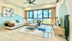 A modern living room with a sofa, coffee table, and a large window offering a view.