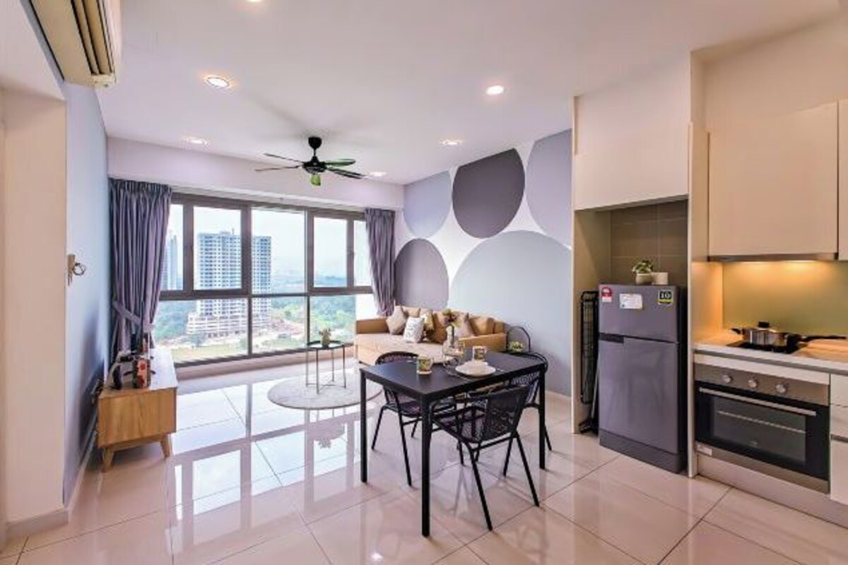 A modern kitchen with a refrigerator, oven, and dining area with a table and chairs.
