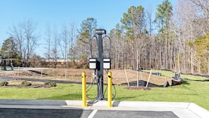 Une zone de stationnement avec un poste de commutation, entourée d’une pelouse et d’arbres.