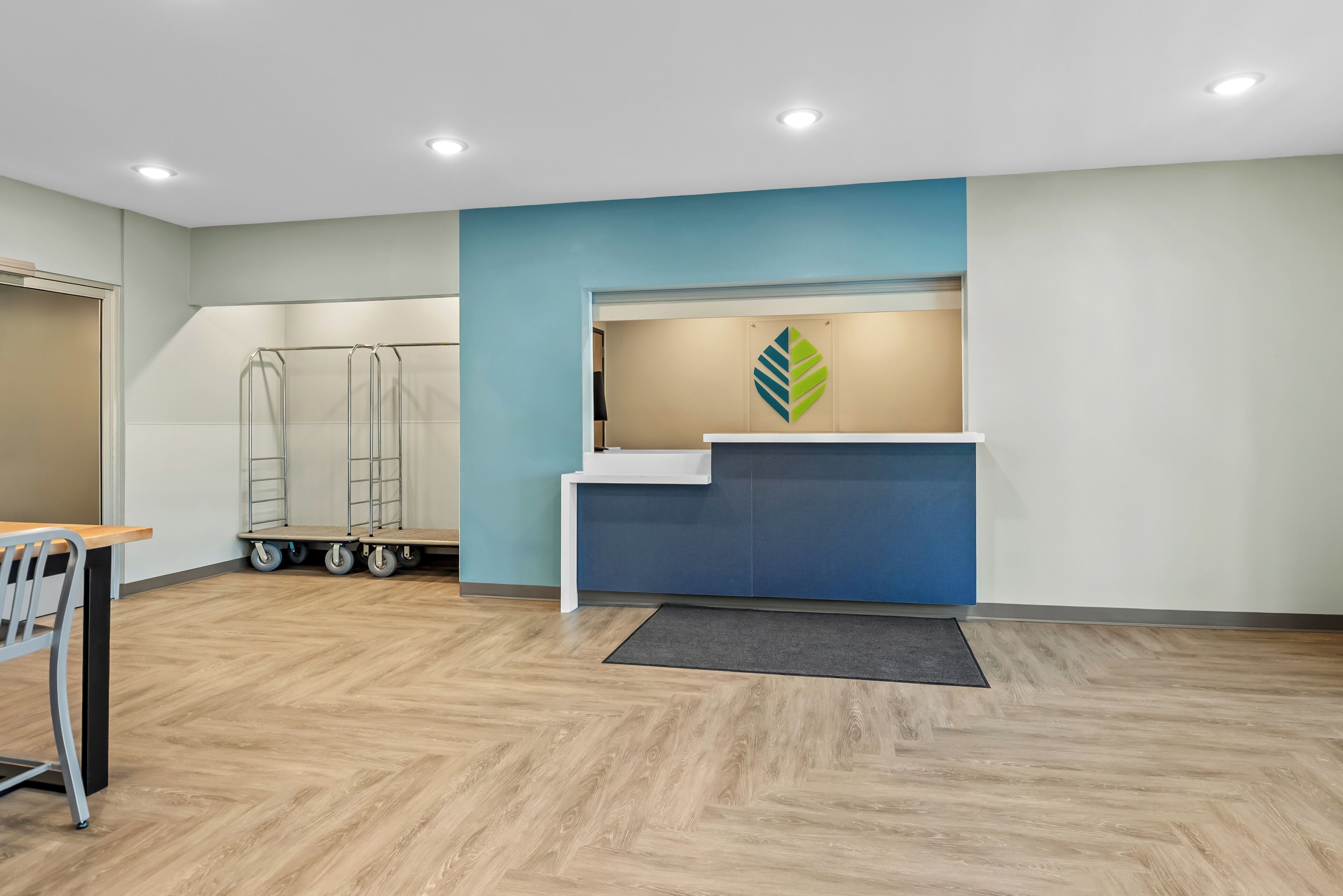 A reception area with a desk, a reception counter, and a wall-mounted logo.