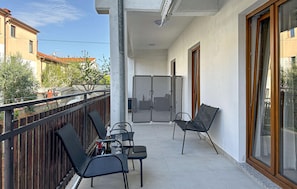 A balcony with a table, chairs, and a glass partition.