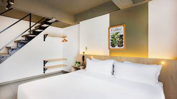 A modern hotel room with a large bed, a wooden headboard, a staircase, and a wall-mounted artwork titled "Coffee".