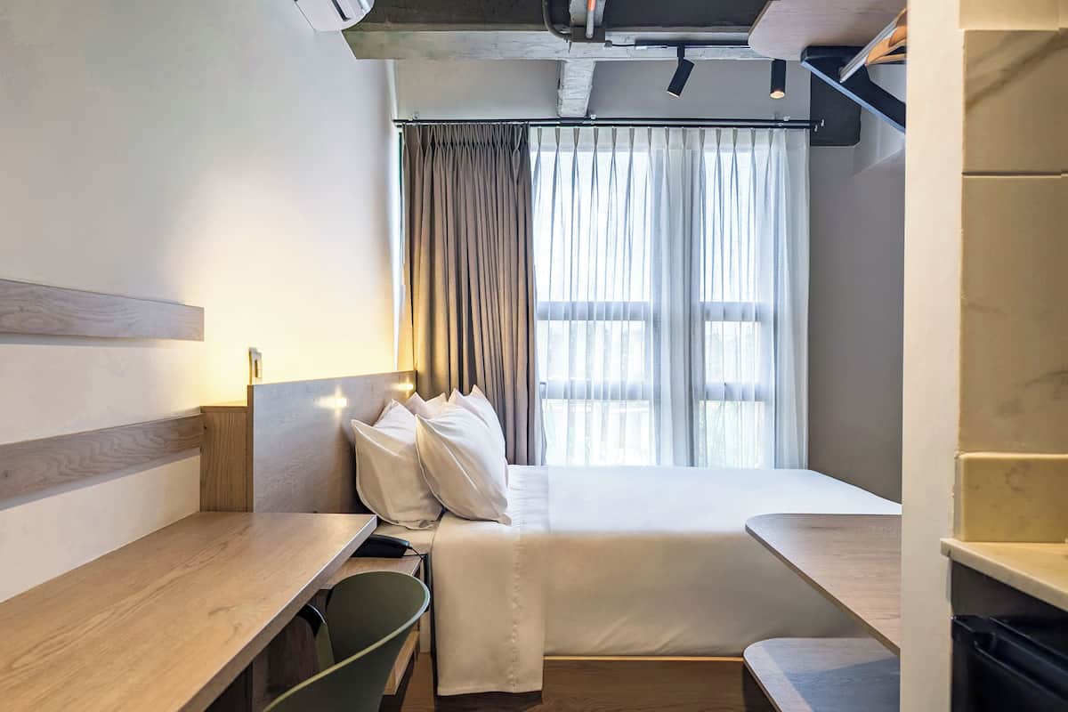 Escritorio, cortinas blackout y tabla de planchar con plancha