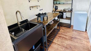 A compact kitchen with a sink, stove, and a small refrigerator.