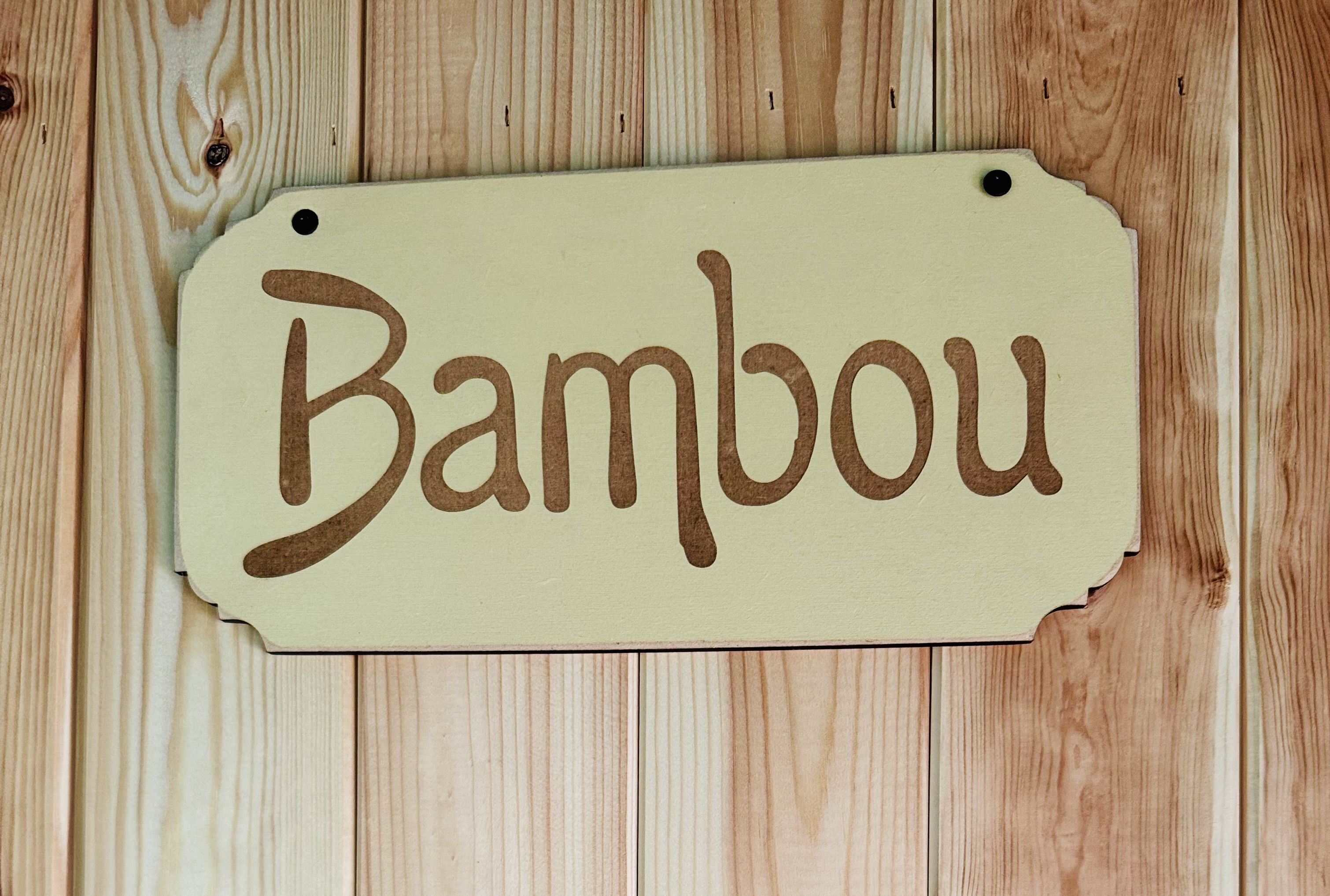 Een houten bord met de tekst 'Bambou'.