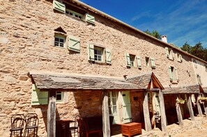 Un edificio de piedra con múltiples ventanas y un porche cubierto.
