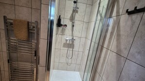 A modern shower area with a glass door, a metal towel rack, and a showerhead. - Walk to East Croydon Station, 15 min direct train to Gatwick and Central London (Greater London)