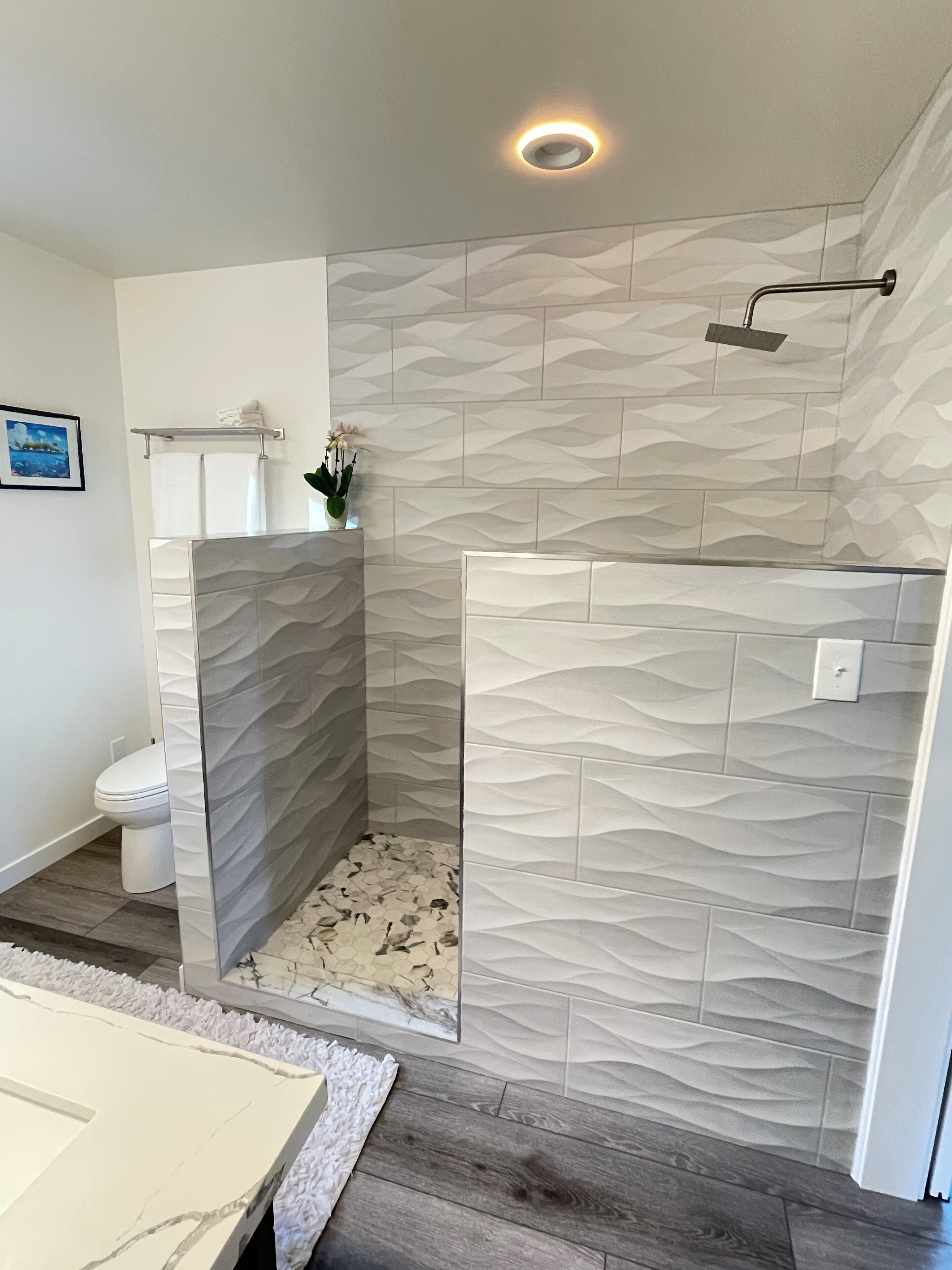 A modern bathroom with a shower enclosure, a toilet, and a sink.