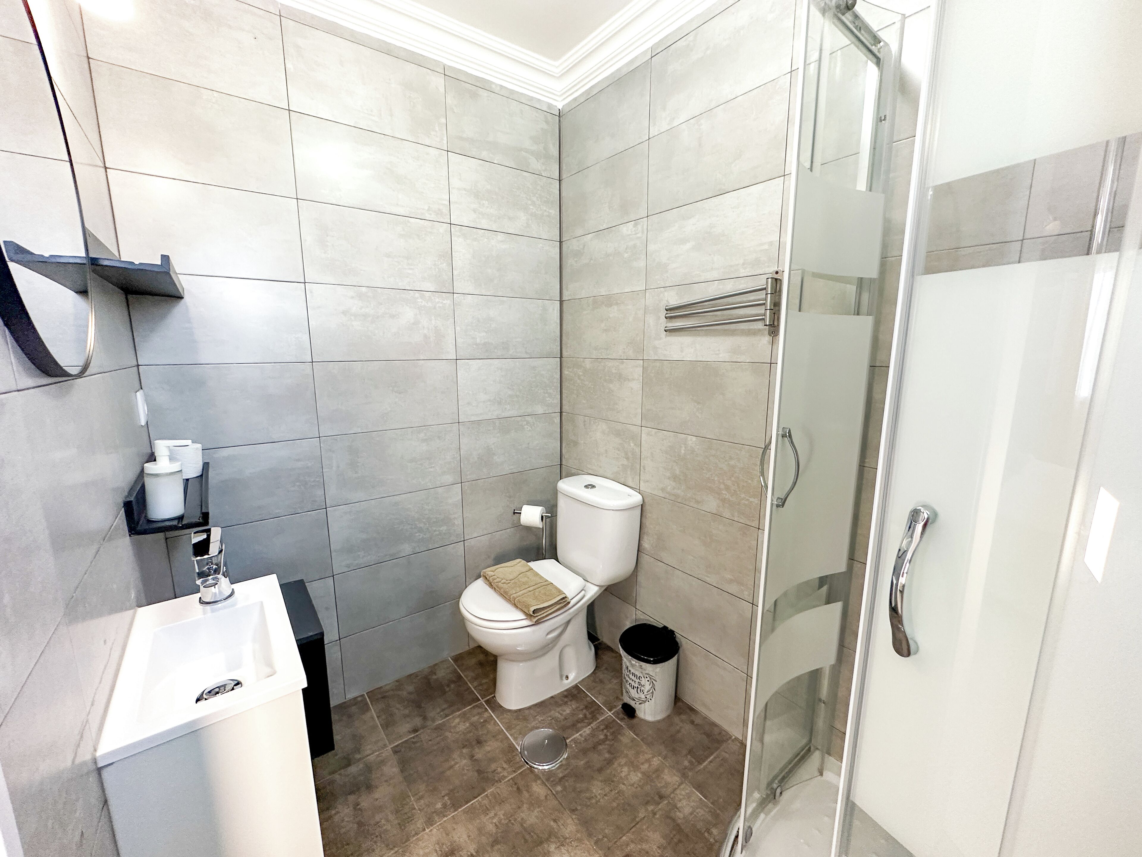 Ein modernes Badezimmer mit Toilette, Waschbecken und Dusche.