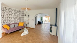 A modern living room with a sofa, a glass coffee table, and a fireplace. - Casa Alagoinha by Umbral (Odemira)